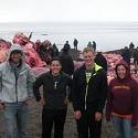 The team posing in front of a whale carcass.